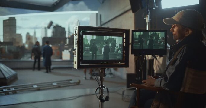 Focused Female Director Seated at Monitors, Reviewing Takes, Directing Actors and Crew, Coordinating Camera, Managing Green Screen Visual Effects for Commercial Film Production Studio Workflow.