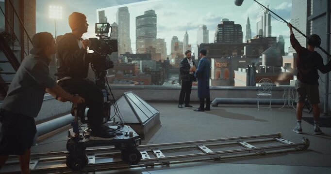 Camera Operator Rides a Dolly on Rooftop Movie Set, Actors Perform Great Dramatric Dialogue While Monitoring Framing on Monitor and Using Virtual Production, Cinematic Movement and Visual Aesthetics.