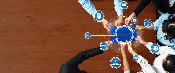 A top-down view of diverse hands engaging with digital icons representing technology and innovation, symbolizing teamwork and collaboration in a modern business environment. Amity