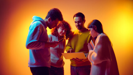 Team reviewing online information together on laptop and mobile devices. Concept of digital research, data sharing, remote tools usage, information exchange and collaborative problem solving.