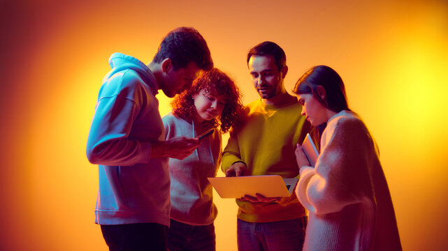 Team reviewing online information together on laptop and mobile devices. Concept of digital research, data sharing, remote tools usage, information exchange and collaborative problem solving. - Powered by Adobe