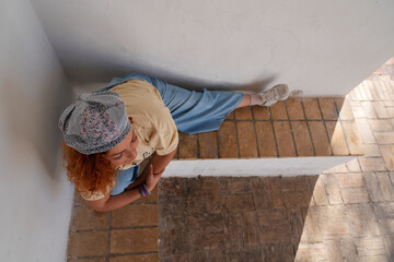 Woman performing a flexible street dance pose on an urban wall
