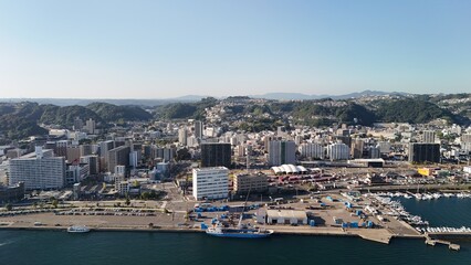 Fototapeta premium Kagoshima Port, Kagoshima Prefecture, Kyushu Island, Japan – View of Seaside City, Towers, Skylines, Urban Streets, Vehicles, Marina, Boats, Ferries, Sea Harbour Surrounded by Mountains