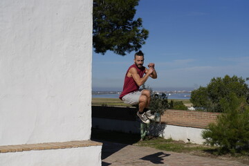 Man performing outdoor fitness training jumping on wall