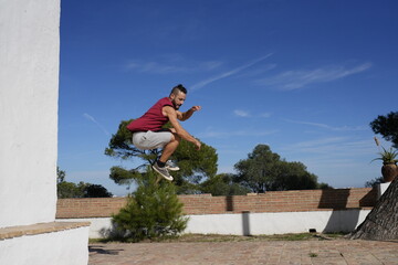 Man performing outdoor fitness training jumping on wall
