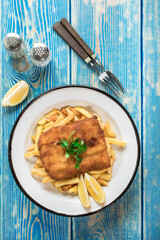 A piece of fried cod with fries on a plate.