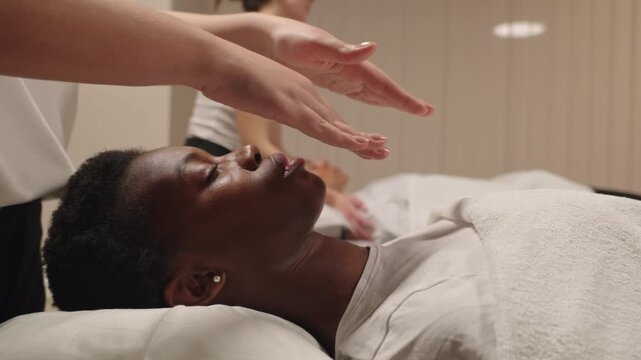Black woman receiving relaxing reiki energy healing session