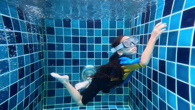 Underwater view of a child's somersault in a swimming pool. Happy children. Slow motion. Childhood, friendship, vacation concept