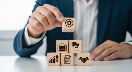 Hand stacking wooden blocks with business icons strategy