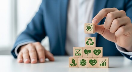 Hand stacking wooden blocks with green eco symbols