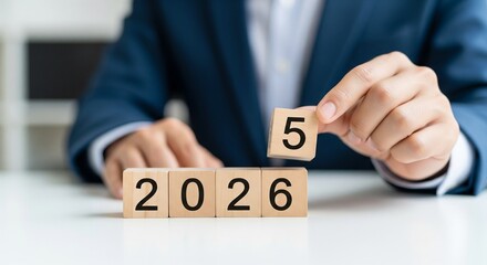 Person placing number 5 block on 2026 year blocks year 2026