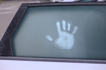 hand touching car window in freezing weather