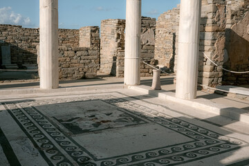 Obraz premium The house of Dionysus with towering marble columns, which rise above the foundations of the ancient house at Delos Island, Greece