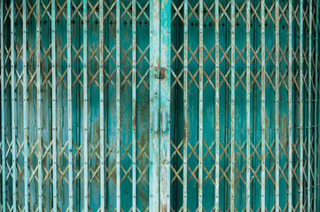 Close up of retractable rusted metal gate and folded door