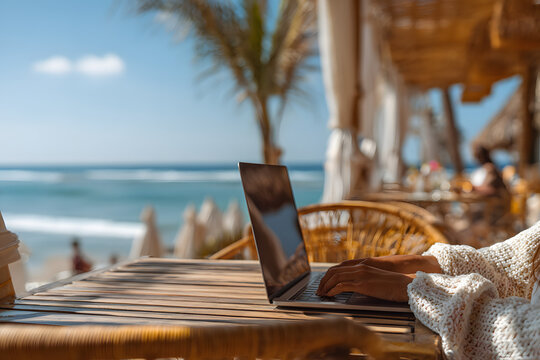 Digital Nomad Typing on Laptop with Coffee at Tropical Outdoor Cafe by the Sea