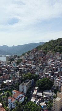 Aerial drone view of Favela Of Cantagalo, Rocinha favelas spread out on the mountain in Sao Conrado , Rio de Janeiro, Brazil.