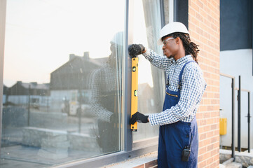 Construction worker checking window level on building exterior