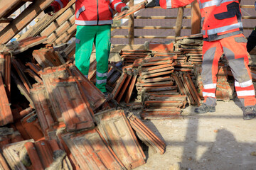 Dismantling and reconstruction of an old roof with safety equipment in teamwork