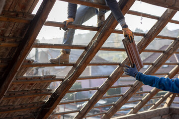 Teamwork of guys dismantling and reconstructing an old house and roof