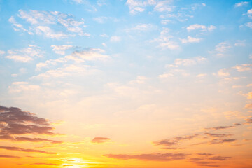 Obraz premium Sunset or sunrise sky with a vibrant gradient of orange, gold, and soft blue. Clear atmosphere with wispy clouds. Peaceful, natural light background. hope, freedom, new day and inspirational Concepts