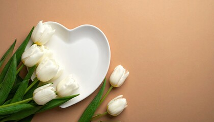 White tulips arranged on a heart shaped plate against a soft brown background.