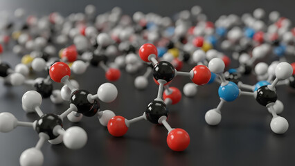 A close-up view of numerous colorful ball-and-stick molecular models, depicting atoms and chemical bonds, scattered across a dark surface, symbolizing scientific research.