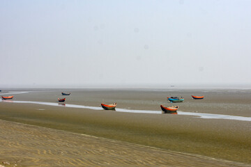 Small fishing boats waiting for high tide in a quiet coastal canal