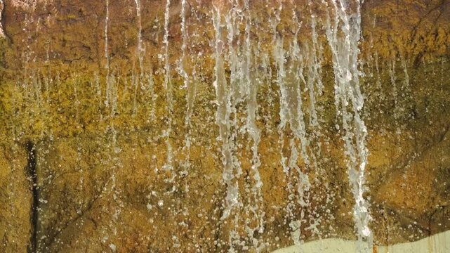 Artificial waterfall against the backdrop of a stone wall on the hotel grounds. High quality 4k footage