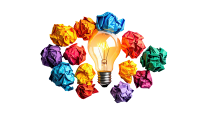 A lightbulb glows brightly, encircled by colorful crumpled paper balls against a black backdrop, symbolizing ideas and creativity