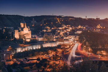 Tbilisi old town glowing at night with light trails from moving © EdNurg