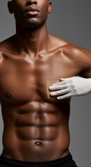 Fototapeta premium Man undergoing hair removal with waxing strip on chest. Body grooming and depilation. Skincare and beauty treatment concept.