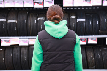 a girl buys rubber on a car