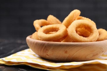 Fried squid rings on black table, closeup