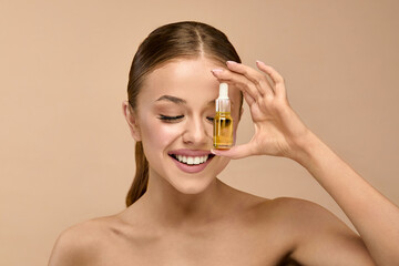 Beauty woman holding serum for skincare in studio background focused on healthy face and glow...