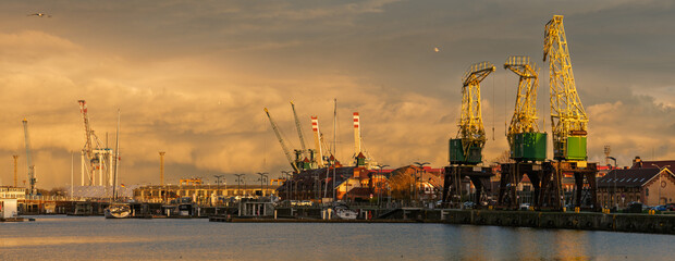 An evening storm with spectacularly illuminated rain clouds over the seaport in Szczecin, Poland.