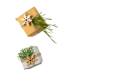 Gift boxes adorned with pine branches and ornaments on a white background, viewed from directly above.