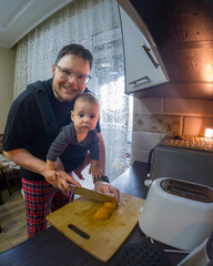 Father Cooking with Baby in Carrier Selfie