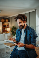 Man using tablet in living room enjoying freelance work