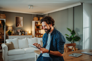 Man smiling enjoying technology browsing tablet at home