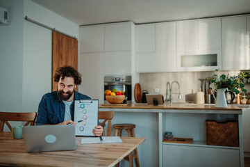 Man presenting chart on video call from home kitchen