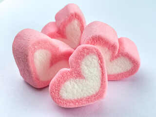 Obraz premium A close-up of a pink heart-shaped marshmallow on a white background. Conceptual ideas for love, romance, sweet gifts, and Valentine's Day.