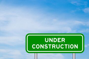 Green color transportation sign with word under construction on blue sky with white cloud background