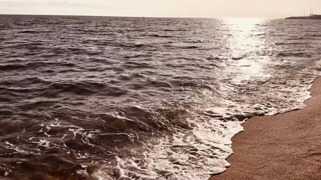 Serene Ocean Waves Washing onto Beach Shore at Sunset