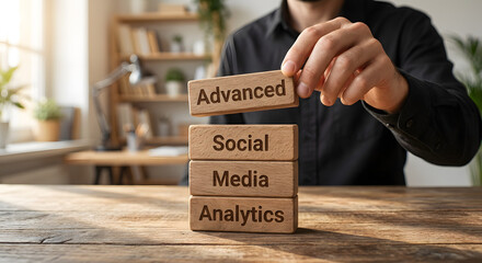 Person Arranging Wooden Blocks with the Words Advanced Social Media Analytics in Modern Office Setting