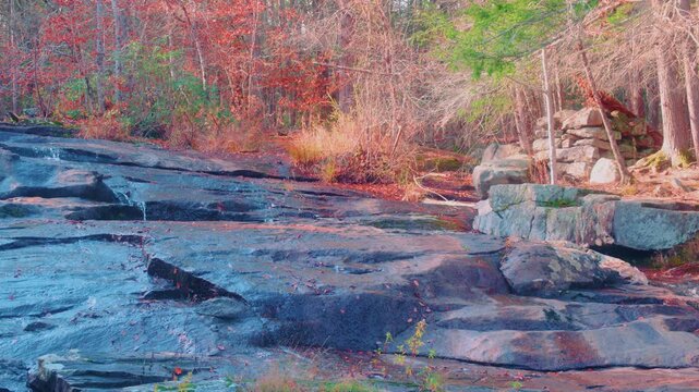 Footage of the beautiful Glendale Falls in Middlefield, Massachusetts during the autumn season. The video captures the Glendale Brook cascading over large, moss-covered rocks, surrounded by vibrant fa