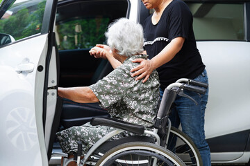 Caregiver help Asian elderly woman disability patient get in her car.