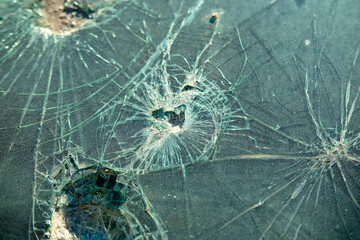 Cracked glass surface with impact holes and shattered texture, bullet hole, violence impact, security breach, broken background damage danger fragility violence stress crisis and destruction, security