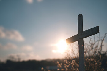 Cross in front of a bright sunset sky