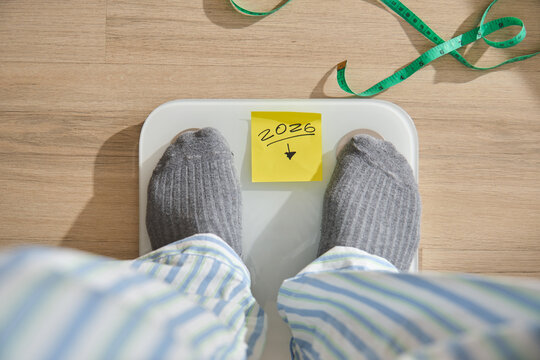 Person standing on a weighing scale aiming for weight loss in 2026