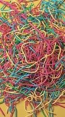 Vibrant Tangle of Colorful Wires Against a Bright Yellow Backdrop